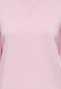 Sweatshirt roz deschis din bumbac, având un guler rotund simplu și un detaliu de cusătură în cruce la gât. Textură uniformă.