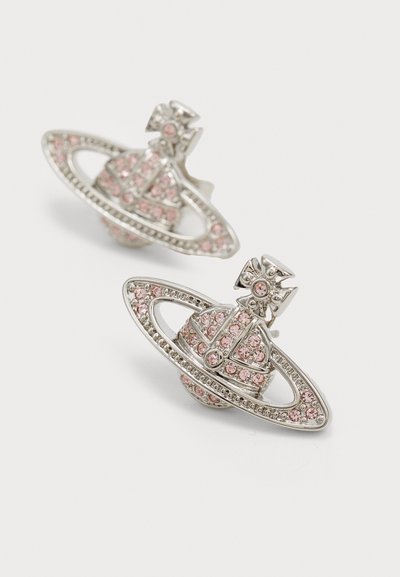 Pendientes en tono plateado con forma de Saturno, con acentos de gemas rosas en el planeta y un detalle de lazo en la parte superior. Acabado texturizado y brillante.