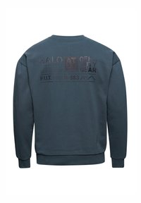 Niebieska bluza z okrągłym dekoltem. Na plecach nadrukowany tekst i grafika w ciemnych kolorach. Miękka tekstura, luźny krój i długie rękawy.