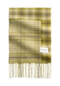 Zielony wełniany szalik w kratę z frędzlami na brzegach oraz białą metką z wytłoczonymi szczegółami marki. Wzór zawiera różne odcienie zieleni i brązu.