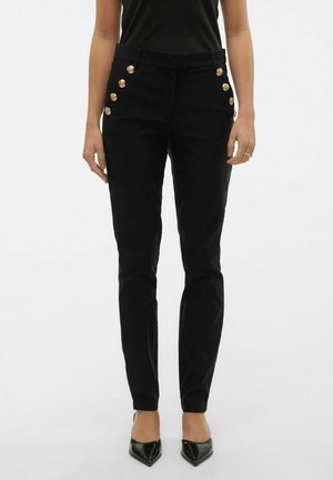Pantalones ajustados negros de tejido elástico con cintura alta, que presentan acentos de botones dorados a lo largo del costado y un diseño de pierna ajustada.
