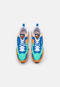 Sneaker colorati con tomaia in rete in turchese e accenti arancioni, sovrapposizioni blu, lacci bianchi e suola testurizzata.