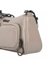 Borsa sintetica color beige chiaro con finitura lucida. Presenta una tasca frontale con cerniera, manico a catena e un accento metallico circolare.