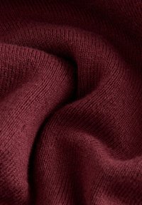 Tessuto lavorato a maglia bordeaux con una texture liscia, che mette in mostra sottili motivi a coste e leggere variazioni di tonalità. Aspetto morbido e flessibile.