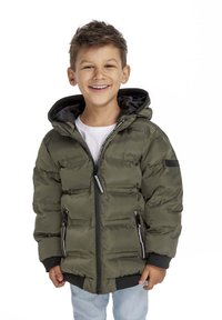 Puffjacka i olivgrönt, med en quiltad design, dragkedjefickor och en svart huva. Buren över en vit skjorta och denimjeans.