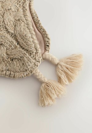 Strikket beige pose med et tekstureret cable-mønster. Har to dekorative kvaster og et blødt indre for.