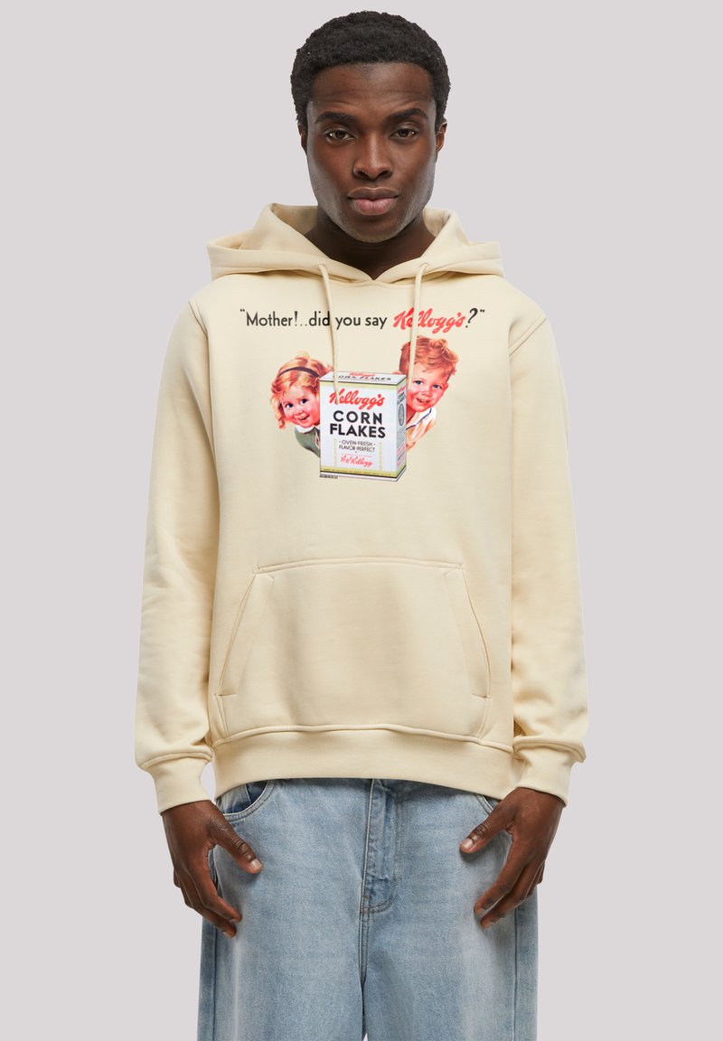 Beige hoodie with front pocket. Features vintage Kellogg's Corn Flakes graphic and quote. Soft fabric, casual design, relaxed fit.