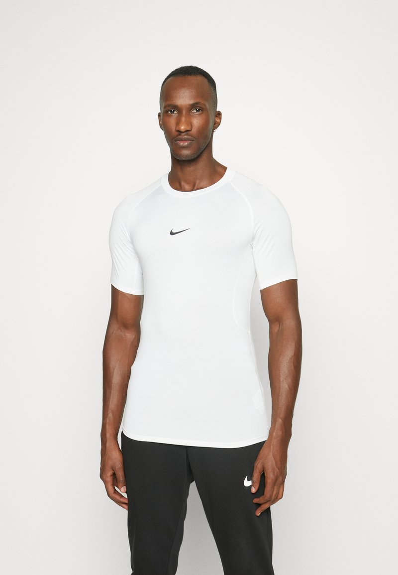 Camiseta deportiva blanca de manga corta, con un diseño ajustado y el logo negro de Nike en el pecho. Tejido suave y acentos de costura en contraste.