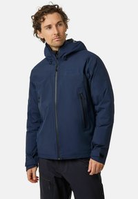 Giacca impermeabile blu navy con cappuccio, chiusura con zip, due tasche frontali con zip, polsini regolabili e un logo discreto sul petto. Tessuto liscio.