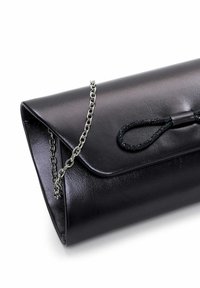 Pochette en cuir noir à texture lisse, équipée d'une bandoulière en chaîne et d'un accent en forme de nœud. Conception à rabat pliant avec une silhouette élégante.