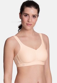 Beige bra with textured fabric, wide straps, and a structured design. Features a seamless, contour cup and a logo accent on the band.