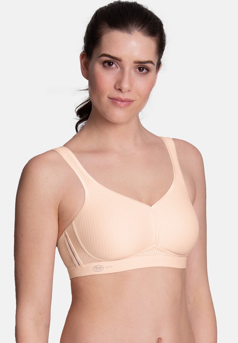 Beige bra with textured fabric, wide straps, and a structured design. Features a seamless, contour cup and a logo accent on the band.