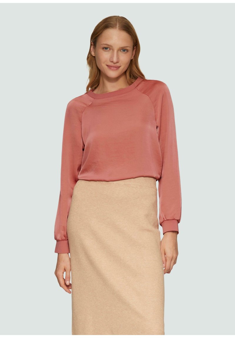 Lange mouwen, zachtroze top van gladde stof met een ronde halslijn, elastische manchetten, gecombineerd met een beige, enkellange rok.
