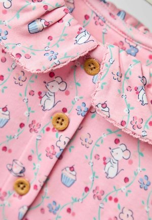 Rosa Baumwollbekleidung mit einem Rüschensaum, Holzknöpfen und einem verspielten Druck von Mäusen, Cupcakes und Blumen in grünen Ranken.