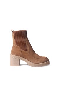 Stivale alla caviglia in suede marrone con bordo elastico a coste, tacco spesso e dettagli di cucitura a contrasto. La suola presenta un bordo testurizzato.