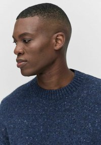 Tummansininen neulepusero, jossa on pyöreä kaula-aukko ja ribbauskaulus. Ominaisuuksia on tekstuurinen kangas, jossa on vaaleampia sinisiä sävyjä ympäriinsä.