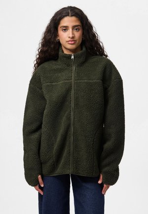 Veste en polaire vert foncé avec un col haut et une fermeture éclair intégrale. Caractéristiques d'une surface extérieure texturée, d'une coupe ample et de poches cachées.