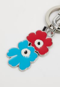 Keychain featuring two flower-shaped charms: one blue and one red, with shiny metallic outlines and black center accents.
