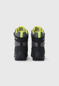 Bottes mi-hautes noires et grises avec des accents jaunes, dotées d'une semelle en caoutchouc texturée et d'un col rembourré, conçues pour la durabilité et le confort.