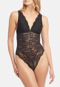 Černý krajkový body s hlubokým výstřihem do V, širokým ramínkovým designem, průhlednou krajkovou texturou a vlnitými okraji podél nohou.