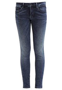 Jeans ajustados en denim azul oscuro, con un ligero desvanecimiento, diseño de cinco bolsillos, cierre con cremallera y una abertura de pierna estrecha.