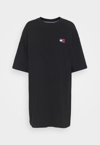 Svart överdimensionerad t-shirt i bomull, med korta ärmar och en liten broderad logotyp i röd, vit och blå på bröstet.