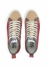 Baskets en velours côtelé beige et rouge avec des accents gris, présentant un design texturé, des lacets blancs et une boucle au talon pour un enfilage facile.