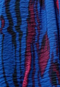 Tissu bleu texturé présentant des motifs ondulés en noir et rose foncé, avec une surface légèrement froissée pour un intérêt visuel et tactile.