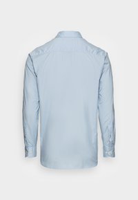 Camicia a maniche lunghe blu chiaro con orlo curvo, polsini con bottone e colletto. Texture liscia, design minimale, senza motivi o dettagli.