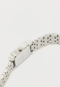 Ezüst rozsdamentes acél óra, téglalap alakú tokkal, sima felülettel és láncos karkötő dizájnnal. Oldalsó koronával és gravírozott hátlappal rendelkezik.