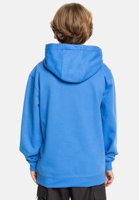 Sudadera con capucha azul en mezcla de algodón, con un ajuste relajado, puños y dobladillo acanalados. Textura suave, vista trasera mostrada.