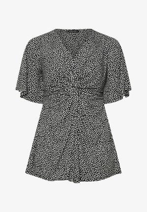 Schwarzes Oberteil mit weißen Punkten, ausgestattet mit kurzen, flatternden Ärmeln und einem taillierten Bund. Hergestellt aus leichtem Stoff mit glatter Textur.