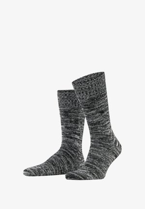 Chaussettes tricotées grises et noires avec un design texturé à côtes, présentant une longueur mi-mollet et un motif de couleurs mélangées.