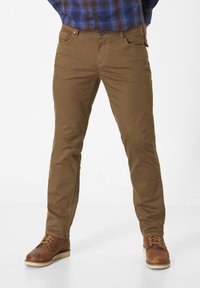 Brown cotton pants with a slim fit, featuring front pockets, and visible stitching details. Paired with brown leather boots.