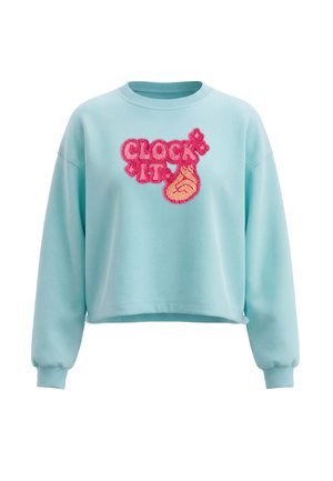 Felpa azzurro chiaro con maniche lunghe e testo rosa con texture "CLOCK IT" accompagnata da una grafica di una mano sul davanti.
