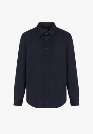 Camisa de manga larga de un oscuro color marino con un collar clásico, cierre de botones y un sutil detalle del logo. Tejido suave con un corte ajustado.