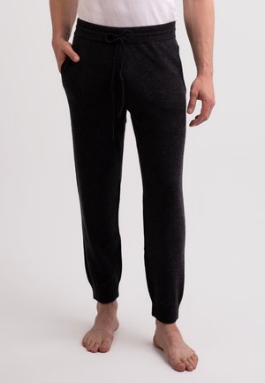 Pantalons joggers noirs et effilés en tissu doux et texturé. Dotés d'une taille élastique avec cordon de serrage et de poches latérales.