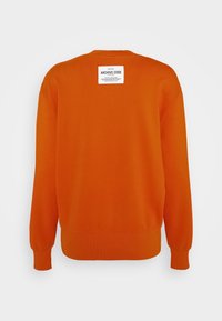 Sudadera naranja, mezcla de algodón, cuello redondo, con puños y dobladillo acanalados. Presenta una etiqueta de marca blanca en la parte posterior cerca del escote.