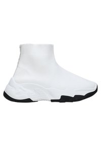 Zapatilla estilo calcetín blanca con parte superior de textil acanalado, suela de goma negra y elementos de diseño suaves y curvados. Sin marcas visibles.