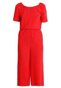 Röd jumpsuit med korta ärmar, vida ben, elastiskt midjeband och små vita prickar över hela. Tillverkad av lätt tyg.