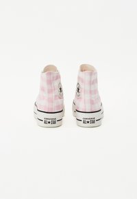 Roze karirana platnena visoka tenisica s crnom oznakom, bijelim gumenim potplatima i crnim akcentima na donjem rubu.