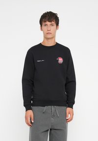 Fekete, pamut keverékből készült pulcsi, kerek nyakkal, bordás mandzsettákkal és elülső logó folttal, piros és fehér kockás részletekkel.