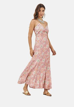 Vestido maxi, con patrón floral en rosa, azul y verde, tirantes finos, tela ligera, combinado con sandalias doradas y collares superpuestos.