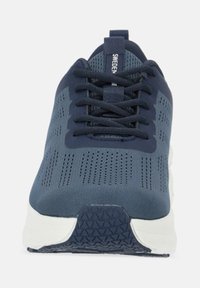 Marina sportskor med ett ventilerande ovandel av mesh, texturerad sula och platta snörningar. Har en vit mellansula och präglad logotyp på tungan.