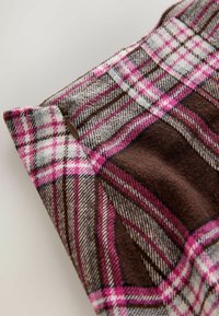 Brown and pink checkered fabric with gray accents, featuring a smooth texture and a slight sheen, highlighted by a visible zipping detail.