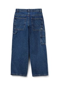 Modré široké džíny s dvojitými zadními kapsami a boční kapsou pro nářadí s viditelným šitím na bílém pozadí.