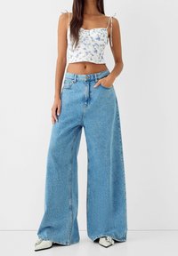 Wide-leg light blue denim jeans with a high waist; the fabric has a soft texture and features a classic five-pocket design.