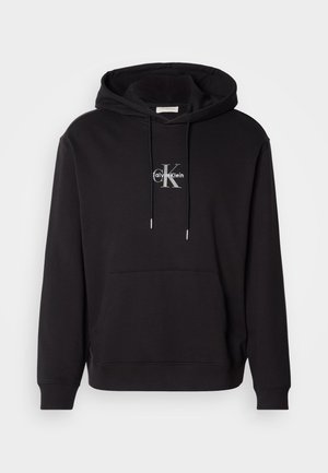 Zwarte katoenen hoodie met een trekkoordcapuchon, kangoeroezak en een zilveren logo met "Calvin Klein" en "CK" op de borst.