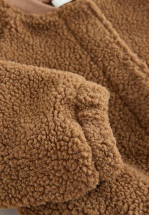 Braunes Fleece-Material mit einer strukturierten, flauschigen Oberfläche. Verfügt über einen runden Ausschnitt und sichtbare Nähte. Weiches und warmes Erscheinungsbild.
