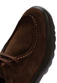 Scarpa in suede marrone con punta arrotondata, cuciture a contrasto e suola in gomma testurizzata. I lacci sono ben fissati per una vestibilità aderente.